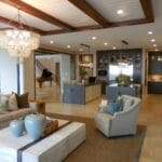 Przestronny salon z eleganckimi dodatkami i żyrandolem przy kuchni