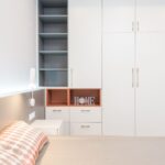 Elegancka sypialnia z białą szafą i łóżkiem w stylu premium