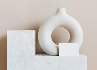 Biały ceramiczny wazon w kształcie pierścienia na marmurowej półce